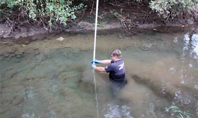 Fish First Construction Team member checking new side-channel depths during excavation
